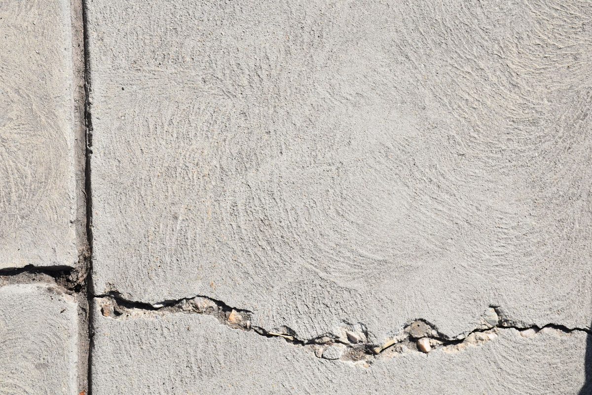 Close-up of a cracked and spalling concrete surface