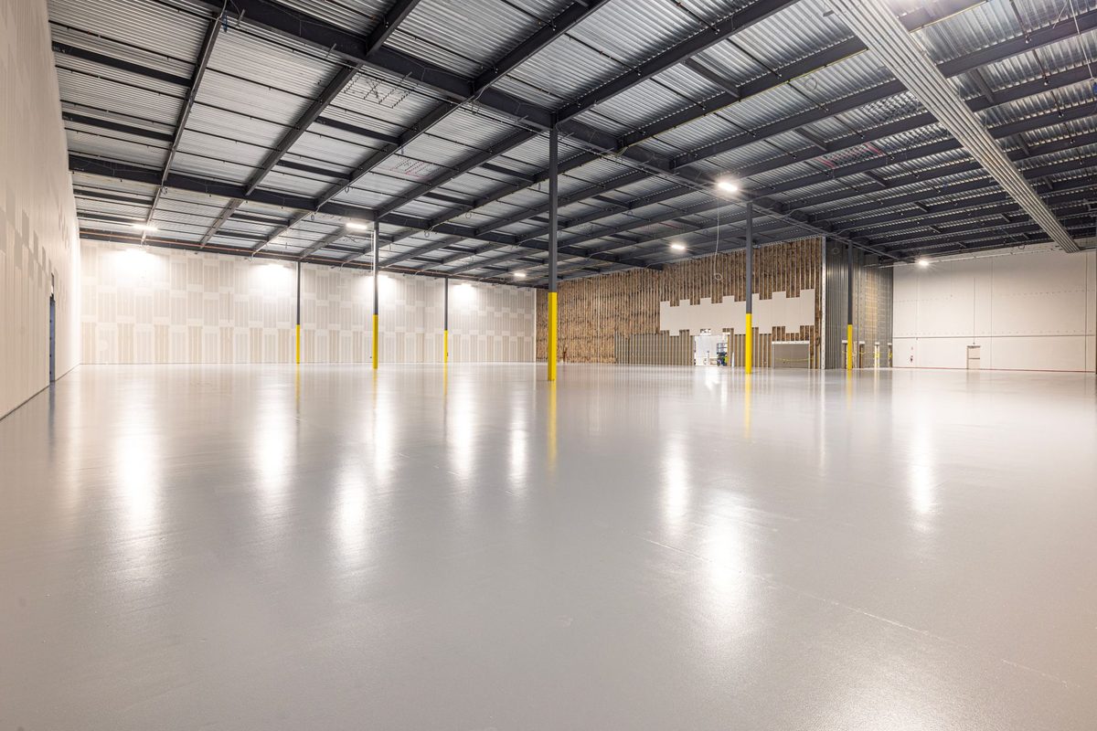 Glossy light gray epoxy floor in an empty warehouse