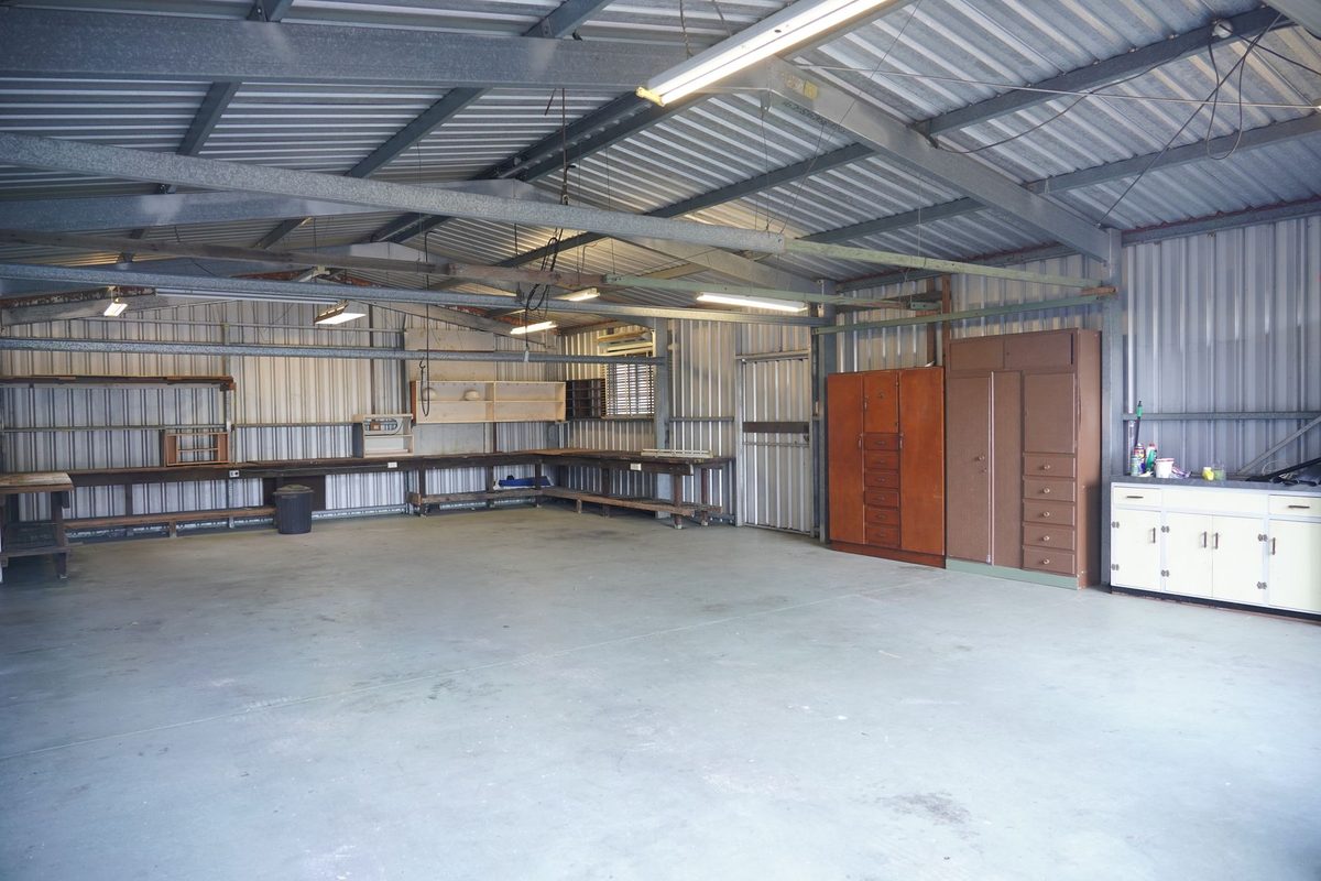 Clean gray coated garage floor with storage cabinets along the wall