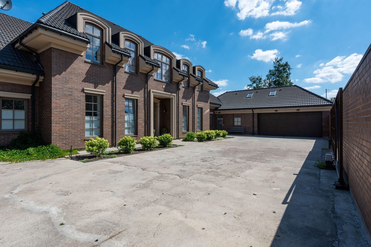Brick home with a wide concrete driveway leading to the garage