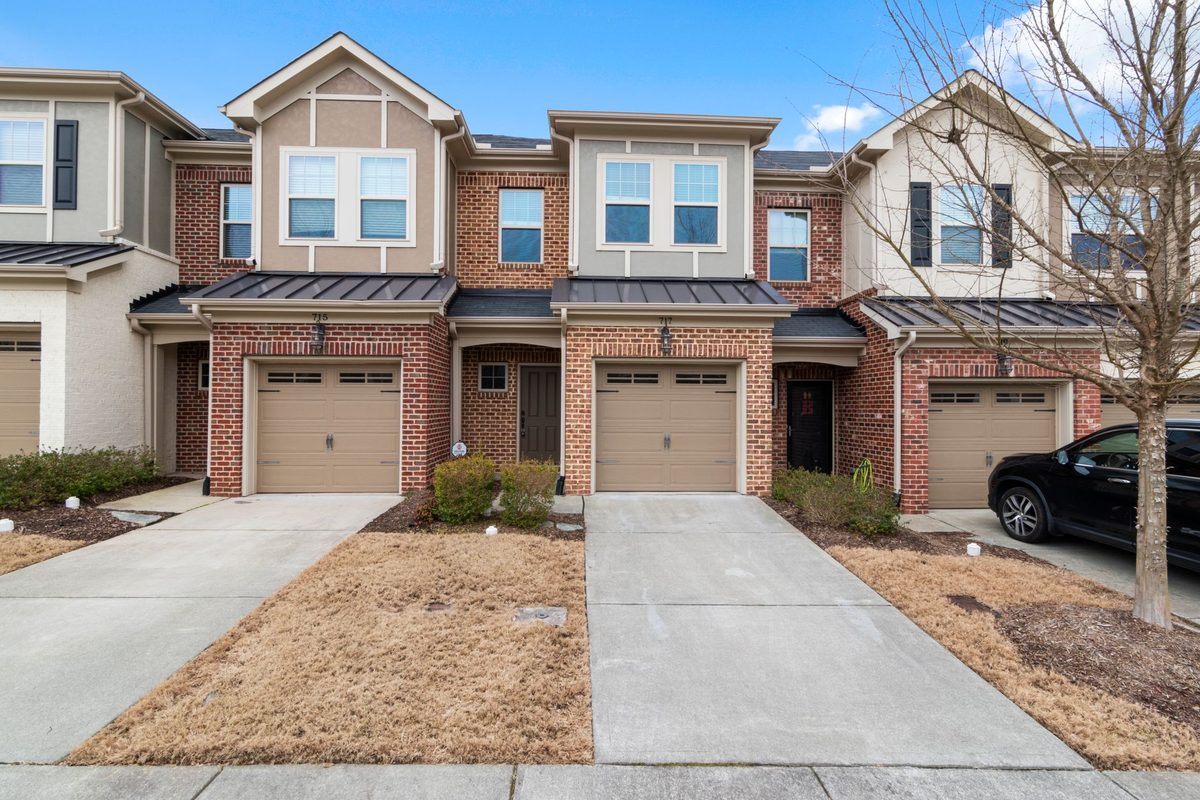 Brick townhomes with attached two-car garages and concrete driveways