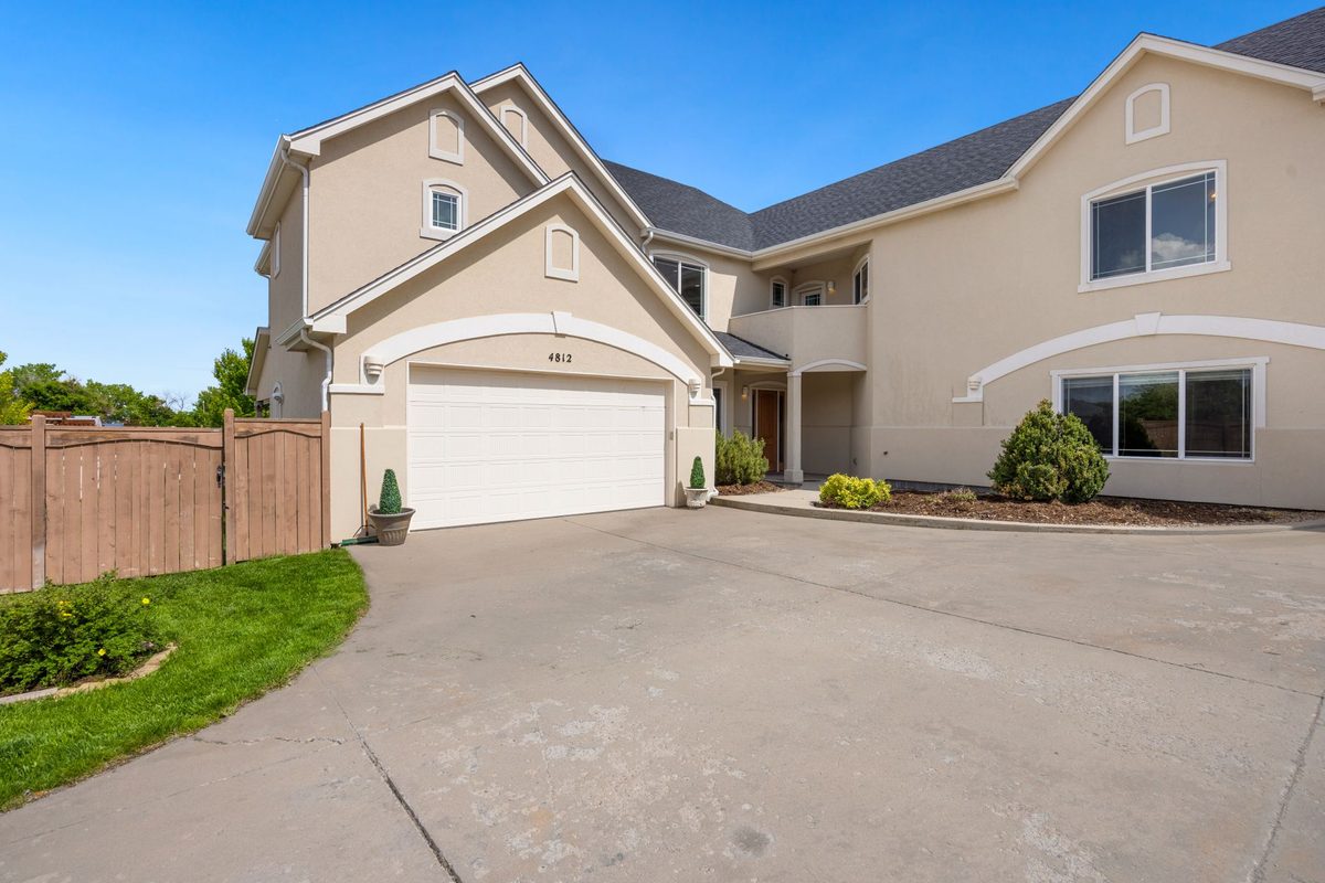 Two-story stucco home with a white double garage door